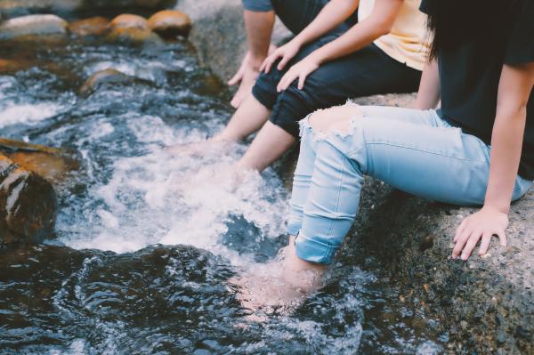 people-in-jeans-with-feet-in-water